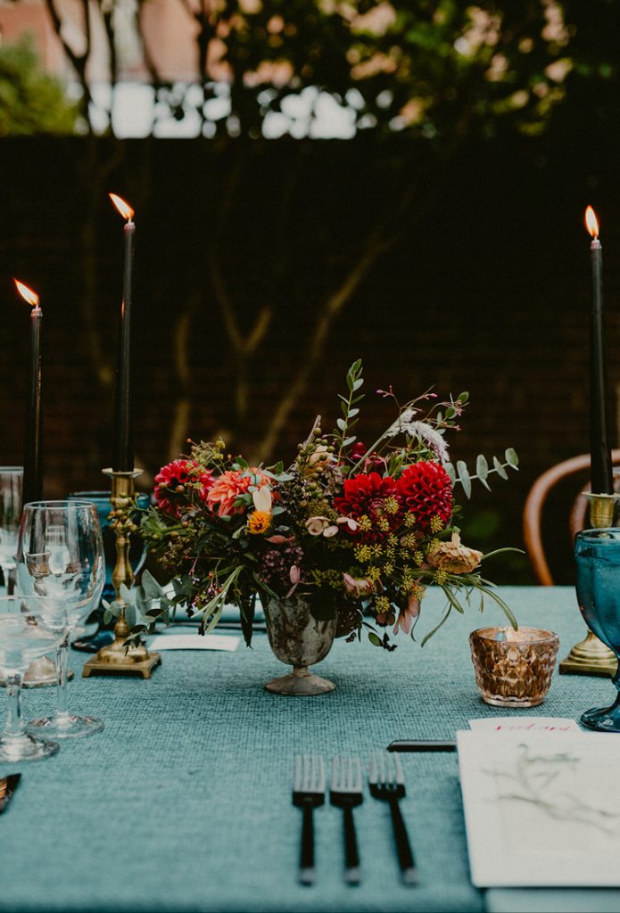 Powel House Wedding Reception | Autumn centerpiece with moody colors of red, oxblood, garnet, amber, mustard yellow, peach, and black in a marbled footed compote vase with taper candles and gold mercury glass nearby | Philadelphia | Flowers by Love 'n Fresh Flowers | Photo by Chellise Michael Photography