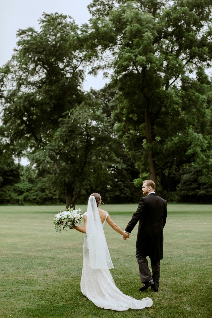 Green and white spring wedding at the Inn at Barley Sheaf || Happy newly weds take a stroll after the ceremony || Florals by Love 'n Fresh Flowers in Philadelphia || Photo by Lev Kuperman