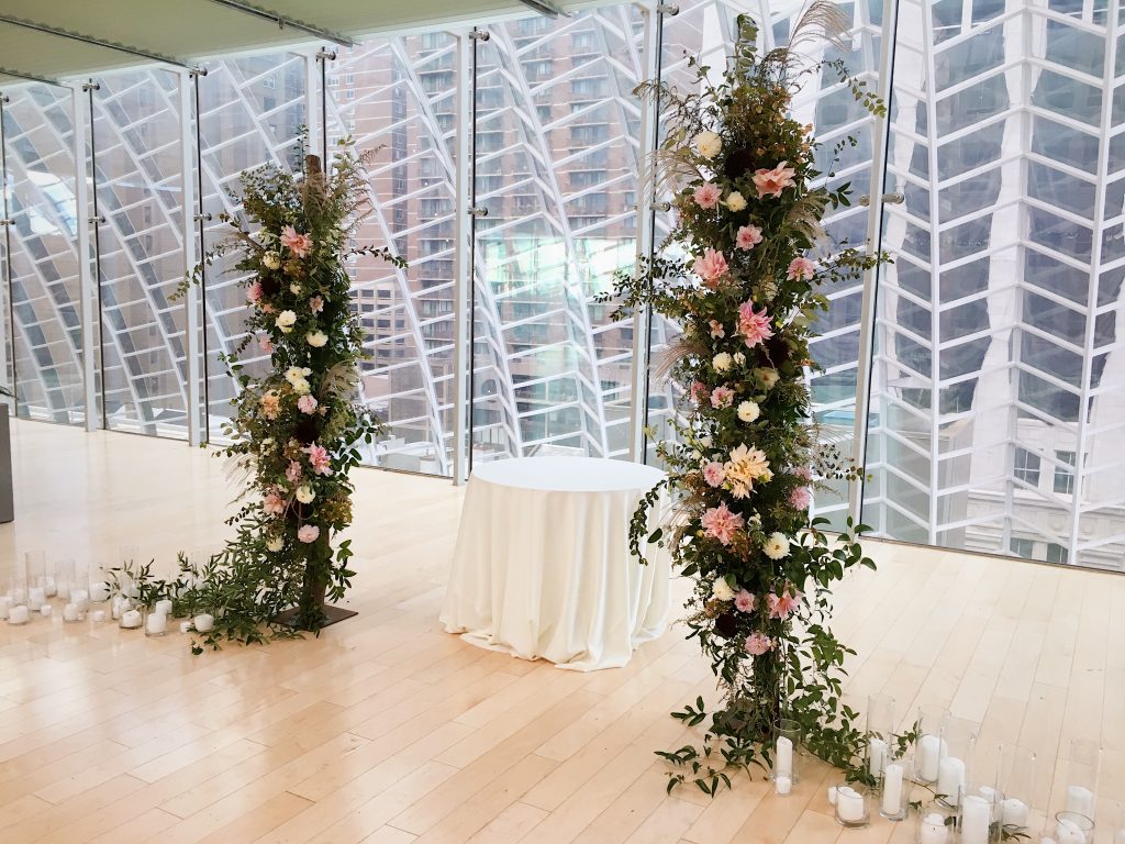 Floral installations of free standing asymmetrical pillars of lush textural botanicals are a modern take on the more traditional wedding ceremony arch, which fit perfectly into the airy space at the Kimmel Center in downtown Philadelphia || Floral Design and photo by Love 'n Fresh Flowers