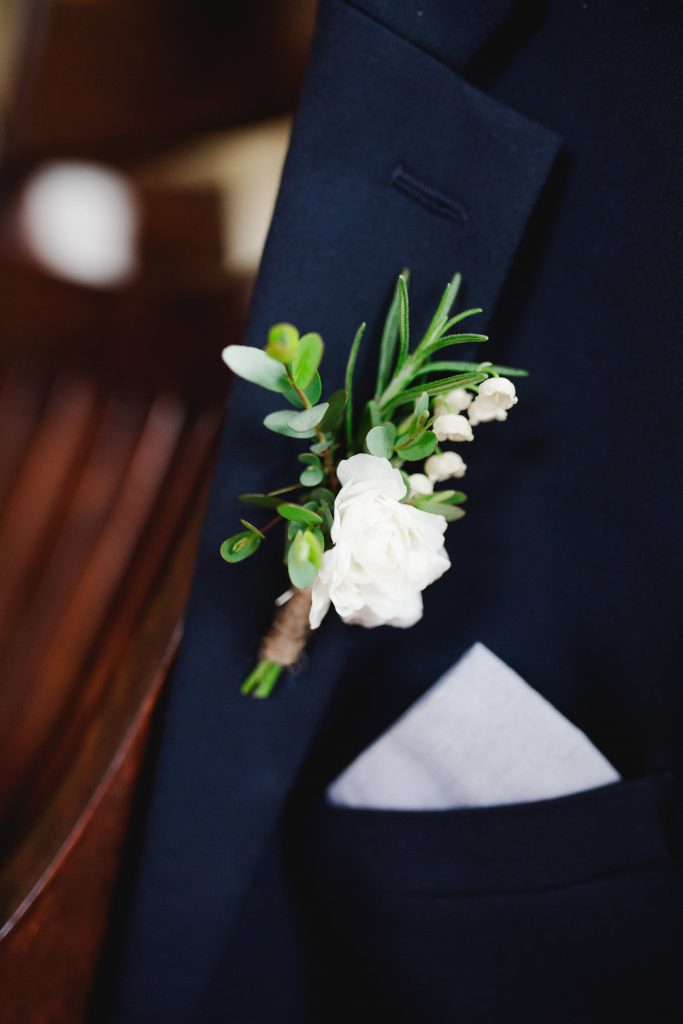 Spring Backyard Wedding | Philadelphia | Groom's boutonniere featuring white ranunculus, lily of the valley, eucalyptus, and rosemary. | Florals by Love 'n Fresh Flowers | Photo by Asya Photography