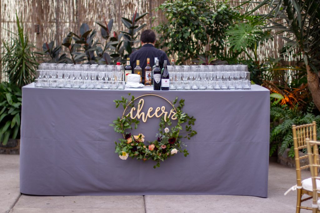 Horticulture Center Spring Wedding || Bar with "Cheers" sign and florals to decorate || Flowers and photo by Love 'n Fresh Flowers