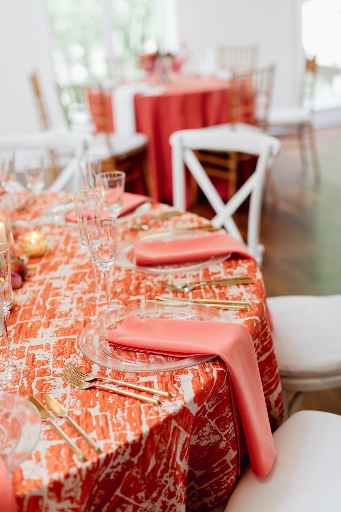 Colorful summer wedding inspiration at Pomme in Radnor | Textured Orange Coral Linen with white chairs |Flowers by Love 'n Fresh Flowers | Photo by Emily Wren Photography